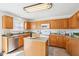 Kitchen with wood cabinets, center island, and stainless steel appliances and fixtures at 8074 Carina Dr, Indianapolis, IN 46268