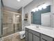 Bathroom with glass enclosed shower, gray cabinets, and neutral color tones at 8727 Faulkner Dr, Indianapolis, IN 46239