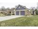This home has a long driveway, attached two-car garage, brick facade, and a manicured lawn at 8901 Rocky Ridge Rd, Indianapolis, IN 46217