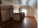 Attic room with wooden floors, window for natural light, and built-in shelving units at 1023 Union St, Columbus, IN 47201
