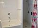 Detailed view of a bathroom featuring white tile walls and a shower with floral shower curtain at 1023 Union St, Columbus, IN 47201