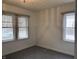 Simple bedroom with gray carpet, large windows with blinds, and neutral decor at 1023 Union St, Columbus, IN 47201