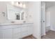 Well-lit bathroom with a double vanity, quartz countertops, modern lighting, and a door to the toilet at 10959 Morab Dr, Zionsville, IN 46077