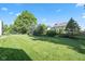 Large backyard with lush green grass, mature trees, and a landscaped garden area at 11866 Weathered Edge Dr, Fishers, IN 46037