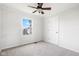 Carpeted bedroom features a ceiling fan, a large window, and neutral walls at 11866 Weathered Edge Dr, Fishers, IN 46037