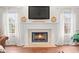 Bright living room showcasing a beautiful fireplace and mantle with a mounted TV and flowing white curtains at 11866 Weathered Edge Dr, Fishers, IN 46037
