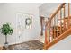 Bright foyer with hardwood floors, staircase, and view into the dining room, creating an inviting entry at 11866 Weathered Edge Dr, Fishers, IN 46037