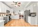 Bright kitchen with white cabinetry, stainless steel appliances, and a view into an adjacent living area at 11866 Weathered Edge Dr, Fishers, IN 46037