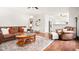 Open-concept living room featuring a leather sofa and chairs, decorative rug, and hardwood flooring at 11866 Weathered Edge Dr, Fishers, IN 46037