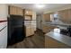 Functional kitchen with wood cabinets, black refrigerator, and a vinyl floor at 1221 Kessler Blvd E Dr, Indianapolis, IN 46220