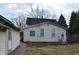 Back of the house featuring yellow siding and view of a detached garage at 1228 E Perry St, Indianapolis, IN 46227