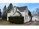 Quaint two-story home with light yellow siding and black roof and shutters at 1228 E Perry St, Indianapolis, IN 46227