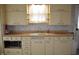 Functional kitchen featuring ample vintage cabinets, a centered sink, and a vintage microwave at 1228 E Perry St, Indianapolis, IN 46227