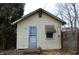 Small shed with a single door, window with awning and yellow siding at 1228 E Perry St, Indianapolis, IN 46227
