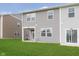 Exterior view of the backyard features green lawn and siding of the townhome at 1231 Langham St, Avon, IN 46123