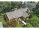 Aerial view of a brick home with a chimney, mature trees, and a well-manicured front yard at 14 Kessler Blvd W Dr, Indianapolis, IN 46208