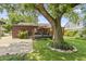 Serene backyard with a wooden deck, lush lawn, and a large tree providing ample shade at 14 Kessler Blvd W Dr, Indianapolis, IN 46208