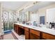 Bright bathroom featuring a double sink vanity, large mirror, and a shower with a decorative curtain at 1657 10Th St, Danville, IN 46122