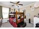 Cozy bedroom with a wooden bunk bed, ceiling fan, and neutral-toned walls creating a warm ambiance at 1657 10Th St, Danville, IN 46122