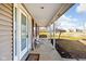 Charming covered front porch with seating, offering a welcoming entrance and a glimpse of the pleasant neighborhood surroundings at 1657 10Th St, Danville, IN 46122