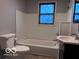 A bathroom with a tub, toilet, and modern sink, featuring a stained glass window at 1900 E Purdue Rd, Muncie, IN 47303