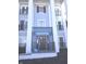Classic building entrance featuring stately white pillars and dark door with address above, 