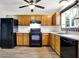 Bright eat-in kitchen featuring wood cabinets, black appliances, and a window over the sink at 2184 Galaxy Dr, Franklin, IN 46131