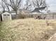 Spacious backyard with storage shed, wooden fence, and a cozy brick fireplace with chairs at 24 N Clay St, Mooresville, IN 46158