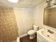 Compact bathroom with a tiled shower, toilet, sink, and wood-look flooring at 24 N Clay St, Mooresville, IN 46158