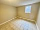Bedroom featuring neutral-colored walls, tiled floors, and a bright window at 24 N Clay St, Mooresville, IN 46158