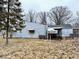A view of the home's back exterior showing boarded-up windows at 2513 W 10Th St, Muncie, IN 47302