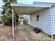 View of the side of the house with a carport area. It is in need of care at 2513 W 10Th St, Muncie, IN 47302