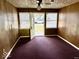 Small entryway with carpet, wood walls, and an open door at 2513 W 10Th St, Muncie, IN 47302