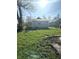 View of the backyard with green grass and detached garage or shed and patio with a grill at 2526 Eastern Ave, Indianapolis, IN 46218