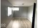 Bright bedroom featuring neutral walls, two windows and wood-look laminate flooring at 2526 Eastern Ave, Indianapolis, IN 46218