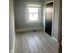 Simple bedroom with a window and a black door, paired with wood-look laminate flooring at 2526 Eastern Ave, Indianapolis, IN 46218