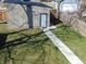 Yard with a shed with a shadow on the grass leading to the white door at 2528 Carrollton Ave, Indianapolis, IN 46205