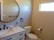 Contemporary bathroom featuring a sleek round mirror and white marble countertop at 2528 Carrollton Ave, Indianapolis, IN 46205