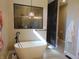 Bathroom features a white soaking tub, accent art and tile flooring at 2528 Carrollton Ave, Indianapolis, IN 46205