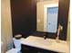 A modern powder room features dark tile walls, a sleek white countertop, and a minimalist black faucet at 2528 Carrollton Ave, Indianapolis, IN 46205
