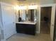 Bathroom featuring double sinks, dark cabinetry and two mirrors at 2528 Carrollton Ave, Indianapolis, IN 46205