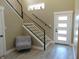 Welcoming entryway with modern staircase, wood-look tile floors, and a chair for added comfort at 2528 Carrollton Ave, Indianapolis, IN 46205