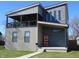 Two-story home featuring modern design with an inviting orange door and covered porch at 2528 Carrollton Ave, Indianapolis, IN 46205