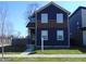 Well-maintained two-story home with dark blue and brown exterior and a simple, manicured lawn at 2528 Carrollton Ave, Indianapolis, IN 46205