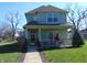 Charming two-story home with a covered front porch, well-maintained lawn, and mature trees at 2528 Carrollton Ave, Indianapolis, IN 46205
