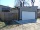 View of the side of a home with a detached garage, concrete driveway, and wooden fence at 2528 Carrollton Ave, Indianapolis, IN 46205