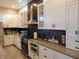 Kitchen featuring stainless appliances, dark backsplash and white cabinetry at 2528 Carrollton Ave, Indianapolis, IN 46205