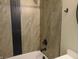 Modern shower featuring dark accents and tiled walls, providing a clean and contemporary space at 2528 Carrollton Ave, Indianapolis, IN 46205