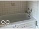 This bathroom includes a white tiled bathtub with an updated faucet at 2842 Indianapolis Ave, Indianapolis, IN 46208