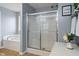 A bathroom features a shower with a glass door, a tub, and grey walls at 3322 Paisley Pointe, Whitestown, IN 46075